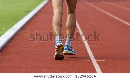 Male jogging at a track and field stadium