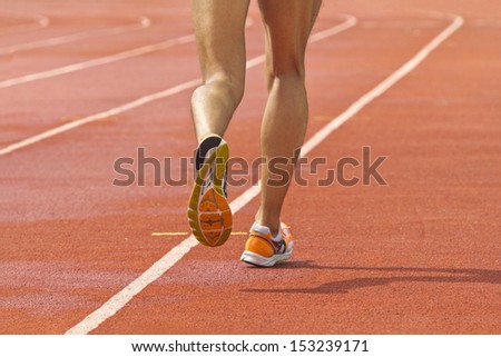Male running at a track and field stadium