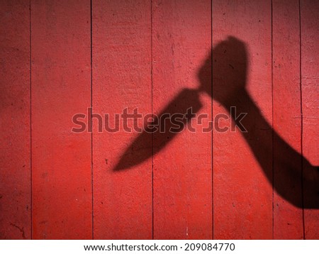 Male Hand Shadow with Kitchen Knife, on wood wall
