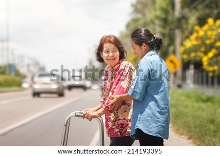 senior woman using a walker cross street