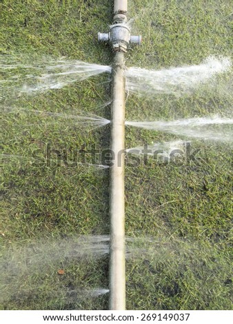 wasting water - water leaking from a hole in a hose