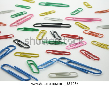 A colorful scattering of vinyl coated paper clips on a white background