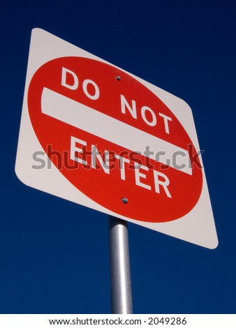A do not enter sign against a deep blue sky.