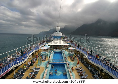 Wide angle view of cruise ship deck sailing along the Na Pali Coast on the island of Kauai in Hawaii.