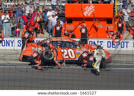 Pit crew works on Tony Stewart\'s #20 car during the Nextel Cup\'s 2006 Allstate 400 at the Brickyard (Aug. 6, 2006)