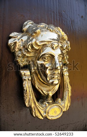 Close up view of a traditional brass door knocker on a door in the Mexican city of San Miguel Allende.