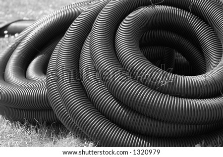 B&W image. A pile of industrial strength hose tied together.