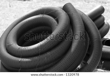 B&W image. A pile of industrial strength hose tied together.