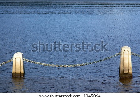 Stone and chain in the rising water. The image is applicable to many concepts.