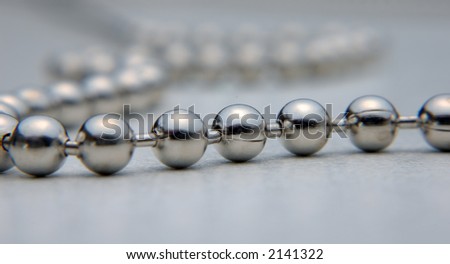 metallic balls chained on light background
