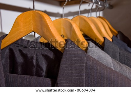 close up of suit men on wooden hangers