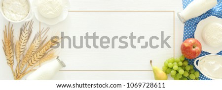 Top view image of dairy products and fruits on wooden background. Symbols of jewish holiday - Shavuot