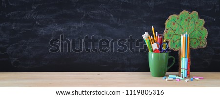 Back to school banner. tree of knowledge and pencils in front of classroom blackboard