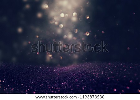 glitter vintage lights background. black, gold and purple. de-focused