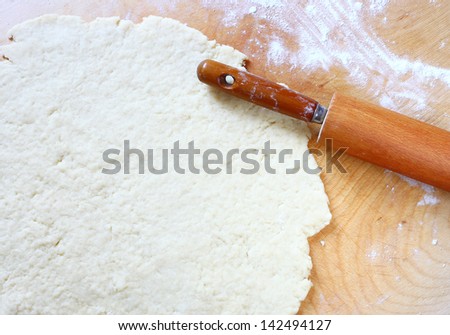 rolling pin with flour and dough on the table