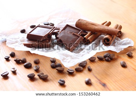 chocolate, cinamon and coffee beans on wooden table. selective focus. natural light.