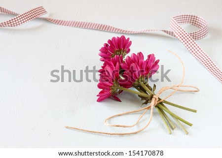 flower and ribbon on wooden blue background