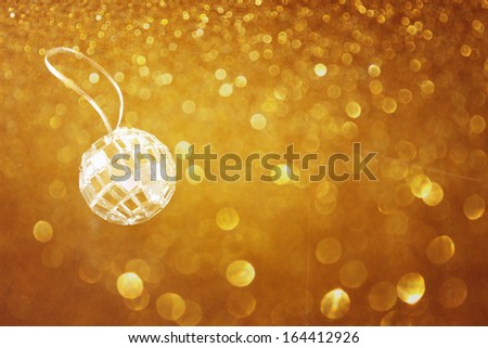 golden abstract bokeh lights and miniature glitter ball. party or music concept.