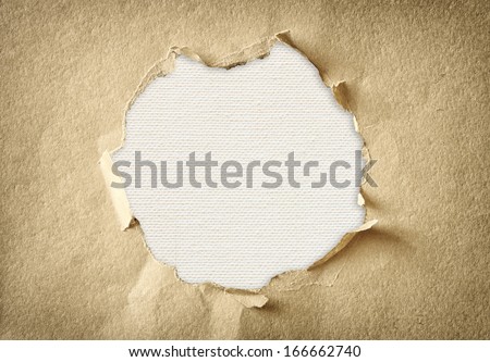 hole made of torn paper over textured canvas background