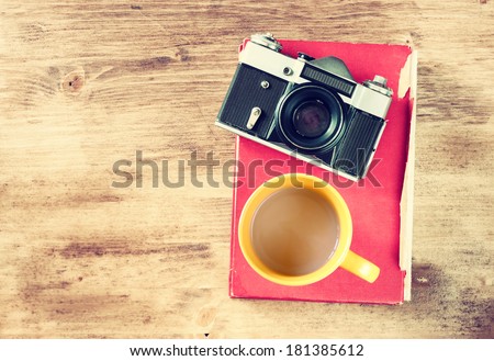 top view of vintage camera red book and coffee cup. filtered image.