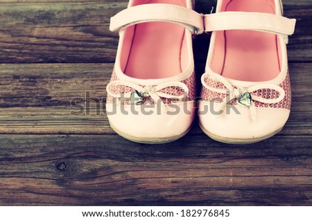 girl shoes over wooden deck floor. filtered image.