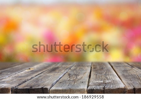 wood board and flower field background. room for product display.