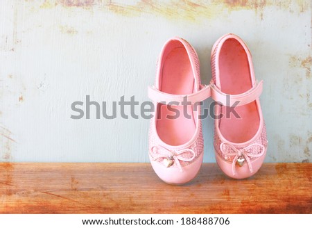 girl shoes over wooden deck floor. filtered image.