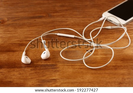 white earphones attached to smartphone. selective focus on earphones.