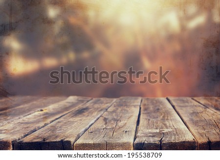 wood board table in front of summer landscape with lens flare.