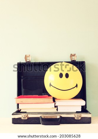 open briefcase books and beach ball. concept for travel or vacation.