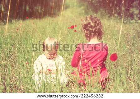 Two cute kids playing in field and warm sunset light.abstract and dreamy concept. image is textured and retro toned