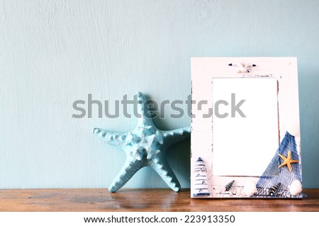 vintage nautical frame with starfish on wooden table. retro filtered image