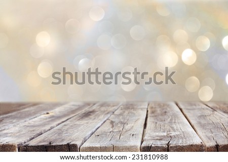rustic wood table in front of glitter silver and gold bright bokeh lights