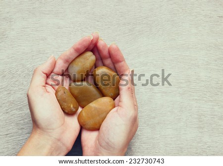 young woman holding river stones