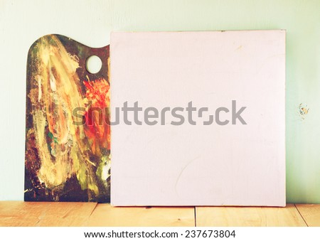 blank canvas or poster with wooden palette on on wooden table and textured background