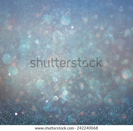 glitter vintage lights background with light burst . silver, blue and white. de-focused.