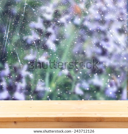 image of front rustic wood boards and background of beautiful flowers field. bokeh lights overlay.ready for product display concept