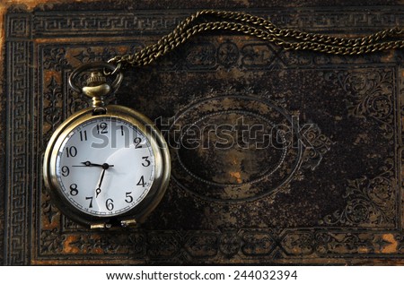 macro image of old vintage pocket watch on antique book. top view. retro filtered image
