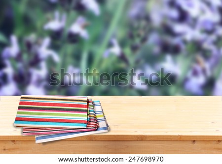 wood board table in front of summer landscape of field with many flowers