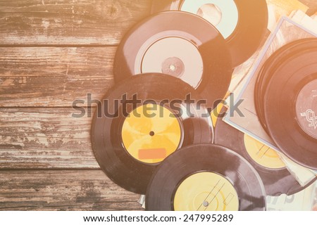 top view of stack of records over wooden table. retro style filter