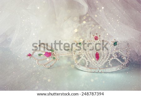 Little girls shiny crown and magic wand and chiffon dress with glitter overlay. selective focus