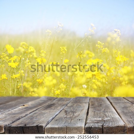 wood board table in front of summer landscape with double exposure of flower field bloom