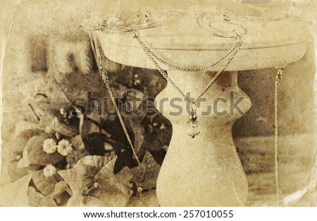 black and white photo of antique vintage necklace on wooden table.