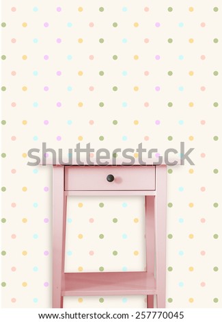 Vintage pink wooden chest drawer near vintage dots wall