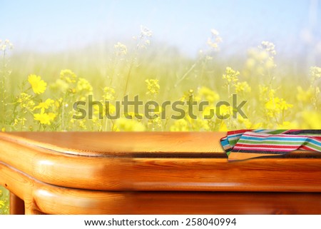 wood board table in front of summer landscape with double exposure of flower field bloom