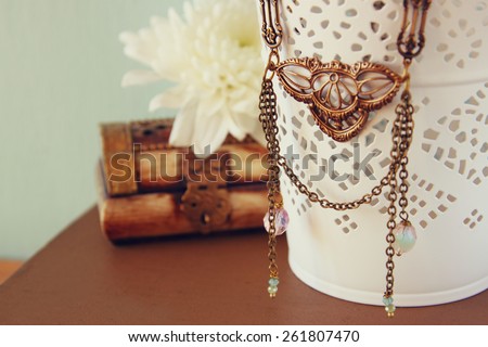 antique vintage necklace on wooden table. retro filtered image.  selective focus