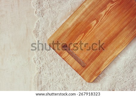top view of Cutting board on wooden table over vintage lace table cloth and wooden table. room for text