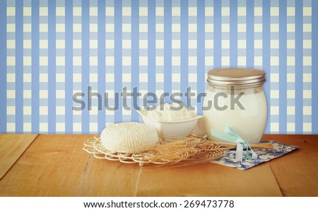 image of greek cheese , bulgarian cheese and milk on wooden table over vintage rustic background. Symbols of jewish holiday - Shavuot