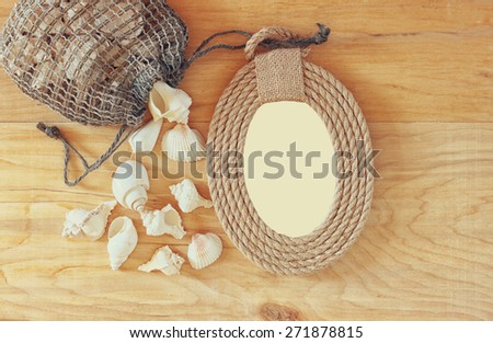 top view of vintage nautical frame from ropes and natural seashells on wooden table