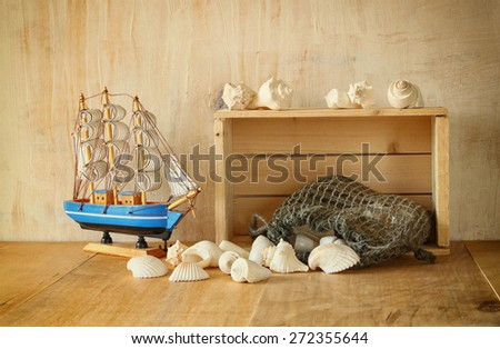 old wooden crate, boat and natural seashells on wooden table
